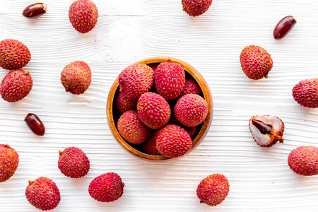 Ripe lychee. Exotic asian fruits in bowl on white wooden desk top-downの写真素材