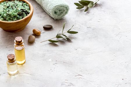 Spa salon concept. Salt, oil and soap near stones on white background copy spaceの写真素材