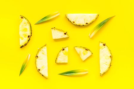 Pineapple slices on yellow background top-down patternの写真素材