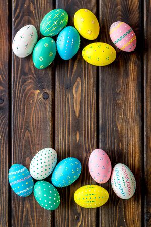 Colorful Easter eggs frame on dark wooden background top-down copy spaceの写真素材
