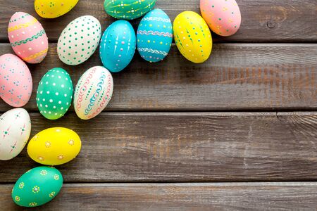 Colorful Easter eggs frame on dark wooden background top-down.の写真素材