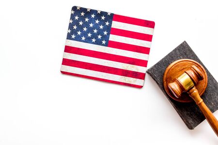 Law and justice in USA concept. Judge gavel near american flag on white background top-down.の写真素材