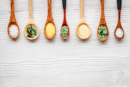 Colorful spa salt in spoons on white wooden background top-down.の写真素材