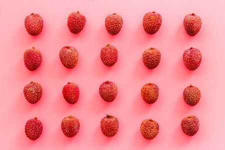 Lychee fruits pattern on pink background flat lay top-down.