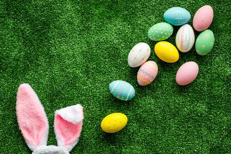Easter concept. Eggs, Bunny's ears on green grass background top-down.の写真素材
