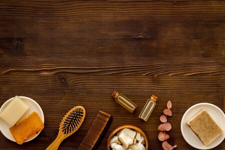 Hair care concept. Coconut oil, brush on dark wooden background top-down frame copy spaceの写真素材