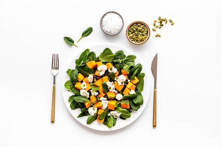 Light dish for lunch. Salad with pumpkin and basil on white background top-down.の写真素材