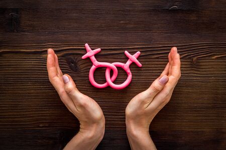 LGBT concept. Female Venus symbols in hands on wooden background top-down.の写真素材