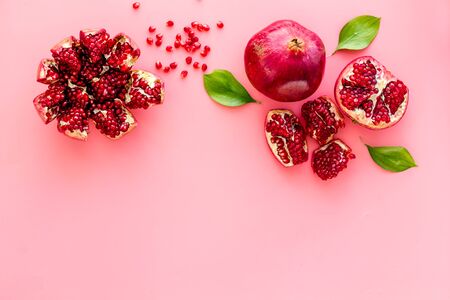 Ripe pomegranate fruit near leaf on pink background top-down copy spaceの写真素材