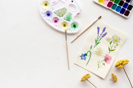 Watercolor painting. Picture with flowers, paints, palette on white background top-down.の写真素材