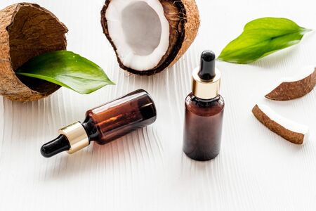 Cosmetic oil in bottle near coconut on white background.の写真素材