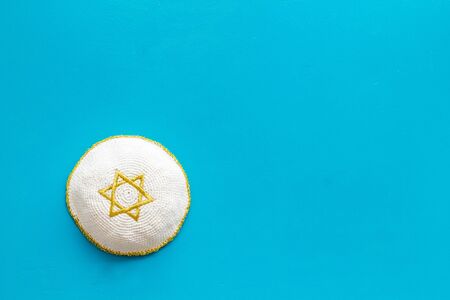 Jewish Kippah Yarmulkes hats with Star of David on blue table. Religion Judaisim symbol. Top view, space for text.の写真素材