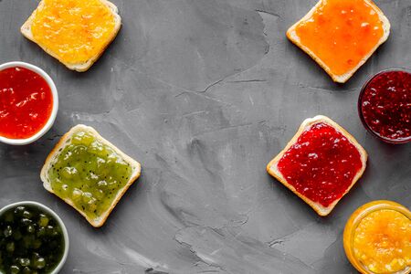 Toast with colorful fruit jam frame on grey background.の写真素材