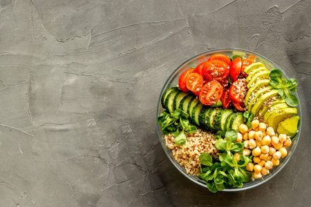 Healhty vegan lunch bowl. Avocado, quinoa, sweet potato, tomato, spinach and chickpeas vegetables...