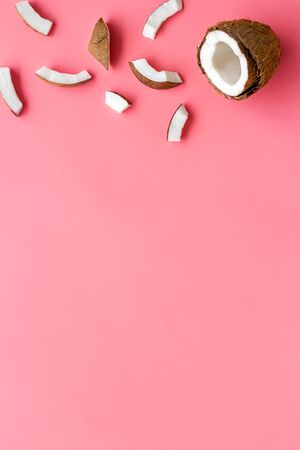 Coconuts frame - halfs and scattered pieces - on pink background top-down copy spaceの写真素材