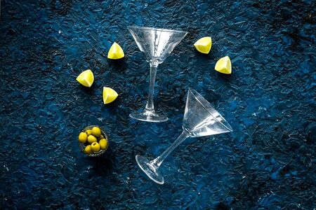 Aperitif drink concept. Martini glasses near olives and lemon on blue background.の写真素材