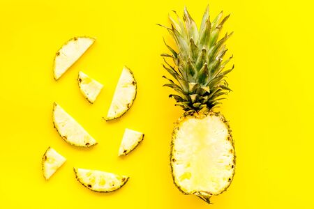 Pineapple - half of fruit and slices - on yellow background top-down.の写真素材