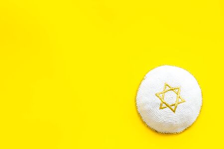 Jewish Kippah Yarmulkes hats with Star of David on yellow table. Religion Judaisim symbol. Top view, space for textの写真素材