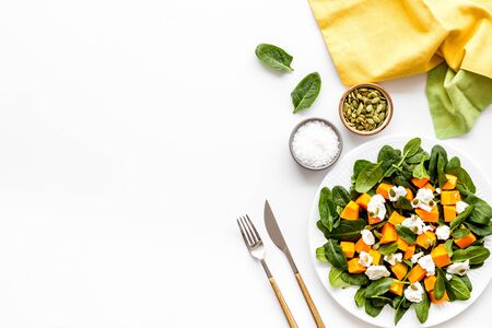 Vegeterian meal concept. Salad with pumpkin and basil on white background top-down.の写真素材