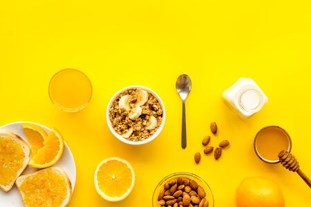 Morning granola near toast and oranges on yellow background top-down.の写真素材