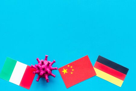 Concept of Corona virus Covid-19 with german, italian and chinease flags on blue background top-downの写真素材