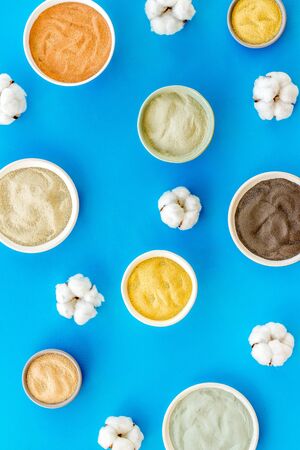 Blue, yellow, white. red, black cosmetic clay background on blue table top-downの写真素材