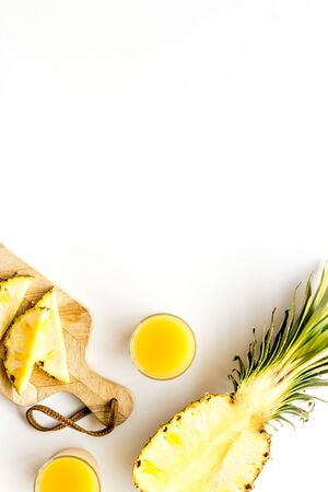 Make pineapple juice. Glasses near sliced fruits on white background top-down.の写真素材
