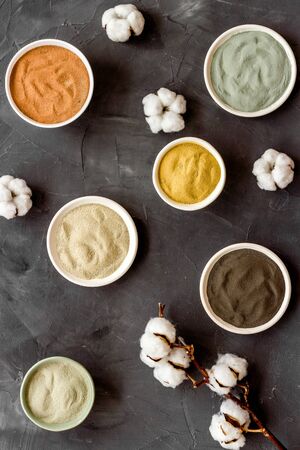 Blue, yellow, white. red, black cosmetic clay background on black table top-down patternの写真素材