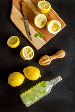 Make lemonade. Drink in bottle near utensil on black background top-down.の写真素材