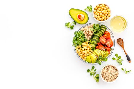 Vegan Buddha bowl. Avocado, quinoa, tomato, spinach and chickpeas vegetables salad on white table top-down.の写真素材