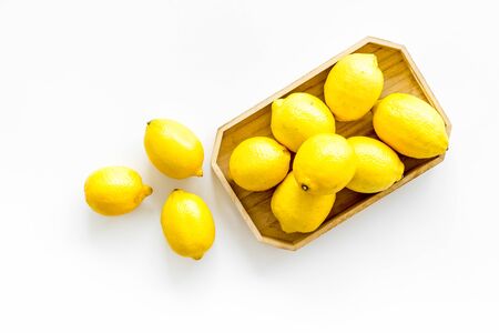 Ripe lemons in tray on white backgroud top-downの写真素材