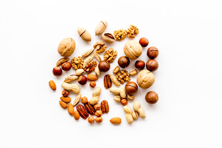 Nuts background - with almond, macadamia, walnut, hazelnut - on white table top-down.