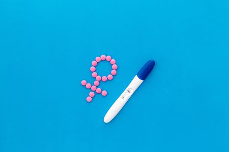 Pregnancy test with two strips and Venus sign - baby girl expectation - on blue background top-downの写真素材