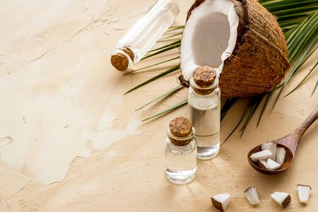 Coconut cosmetics. Organic oil in small bottles on beige background copy spaceの写真素材
