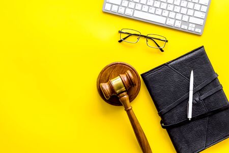 Judge gavel near documents and keyboard - lawyer concept - on yellow background top-down copy spaceの写真素材