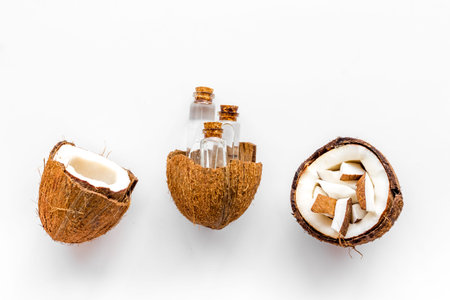 Coconut cosmetics. Organic oil in small bottles on white background top-down