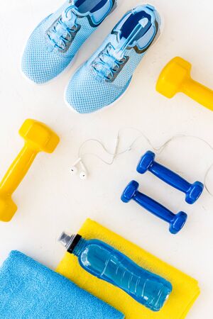 Fitness flat-lay with sheakers, dumbbell, towel on white background top-downの写真素材
