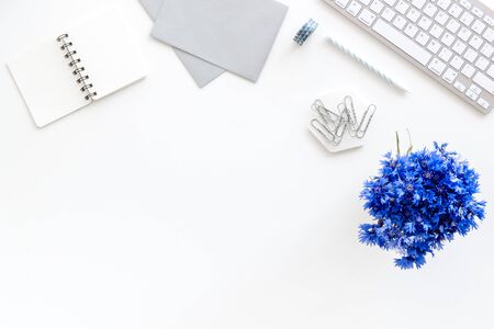 Spring inspiration concept. Work desk with cornflowers bouquet on white background top-down frame copy spaceの写真素材