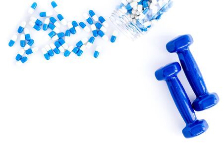 Dumbbells and creatine capsules - sport training concept - on white background top-down.の写真素材