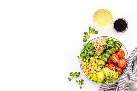 Vegan bowl. Avocado, quinoa, tomato, spinach and chickpeas vegetables salad on white table top-down copy spaceの写真素材