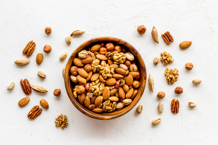 Mixed nuts in bowl on white background top-down
