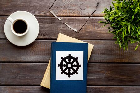 Tripitaka Buddhist holy book near Wheel of dharma - on wooden table top viewの写真素材