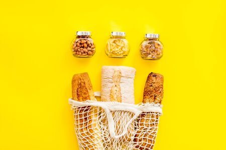 Eco bag, glass jars on yellow background, top view. Zero waste food storage conceptの写真素材
