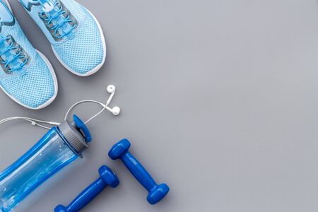 Sport background with sneakers and dumbbells on grey table top view.の写真素材