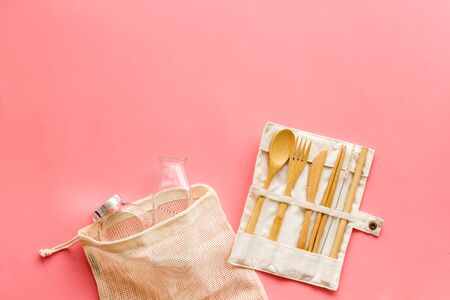 Cotton eco bag and wooden tableware on pink background, top view. Zero waste, plastic free concept copy spaceの写真素材