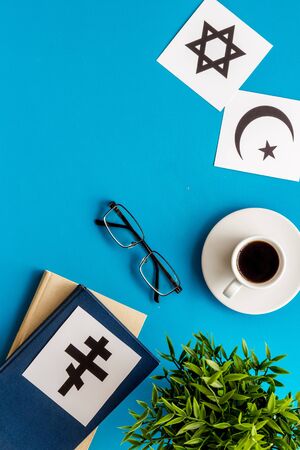 Interfaith dialogue concept. World religions symbols near book on blue background top view copy spaceの写真素材