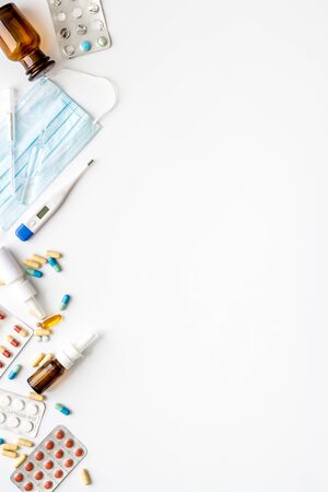Flu treatment concept with medicine and facial mask on white background top view copy spaceの写真素材