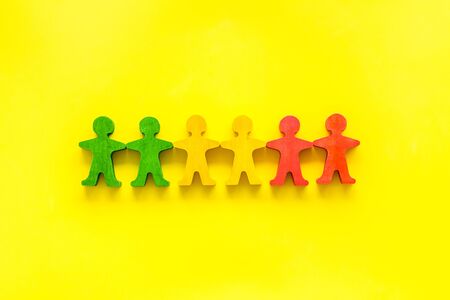 Tolerance, social protection, anti-discrimination concept. Wooden human figures on yellow table, top view.の写真素材