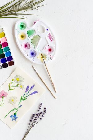 Watercolor painting. Picture with flowers, paints, palette on white background top-down.の写真素材