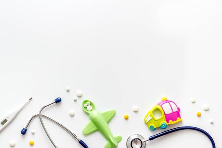 Stethoscope, toys and pills - baby flu and cold concept - on white background top view.の写真素材
